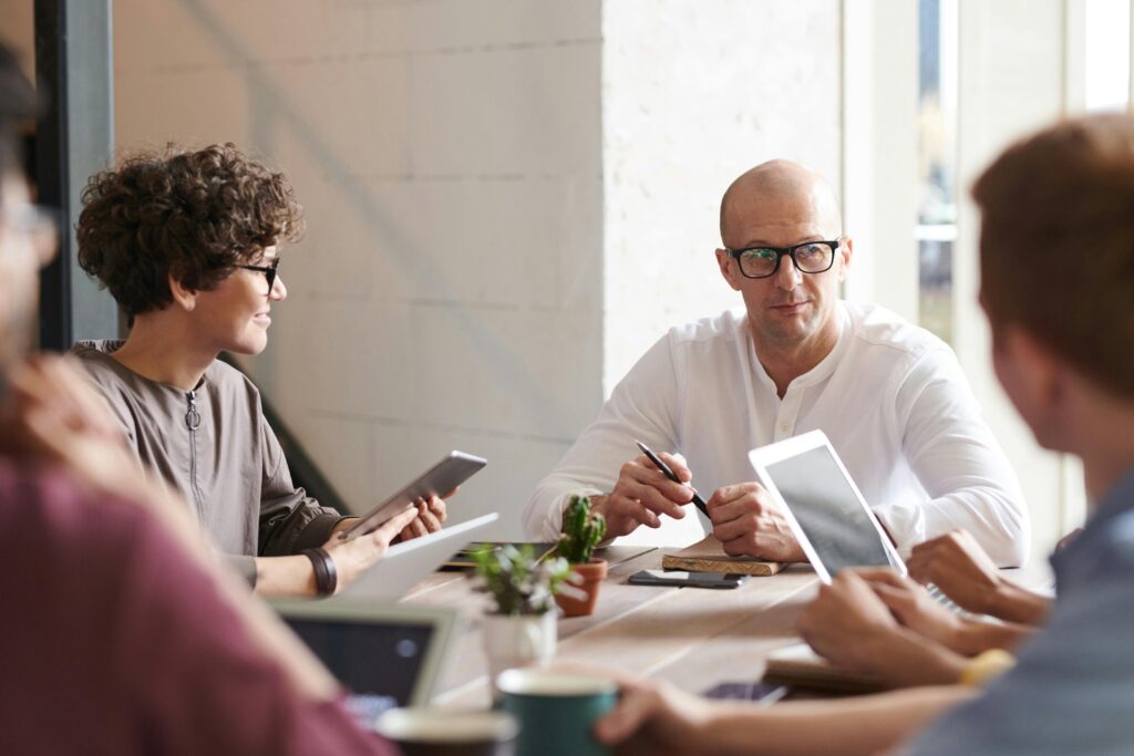 Photo of man sitting in front of people